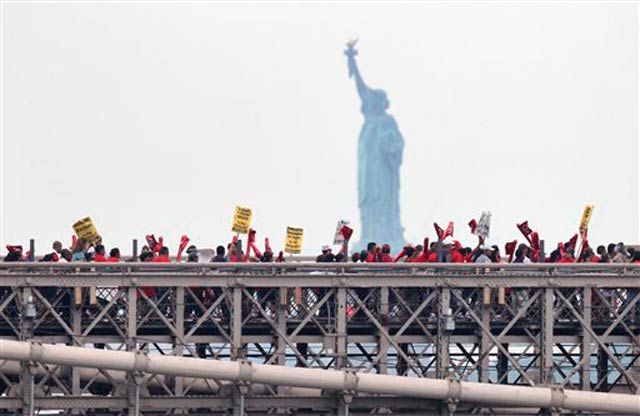Protesters on the Brooklyn Bridge, with the Statue of Liberty in the background